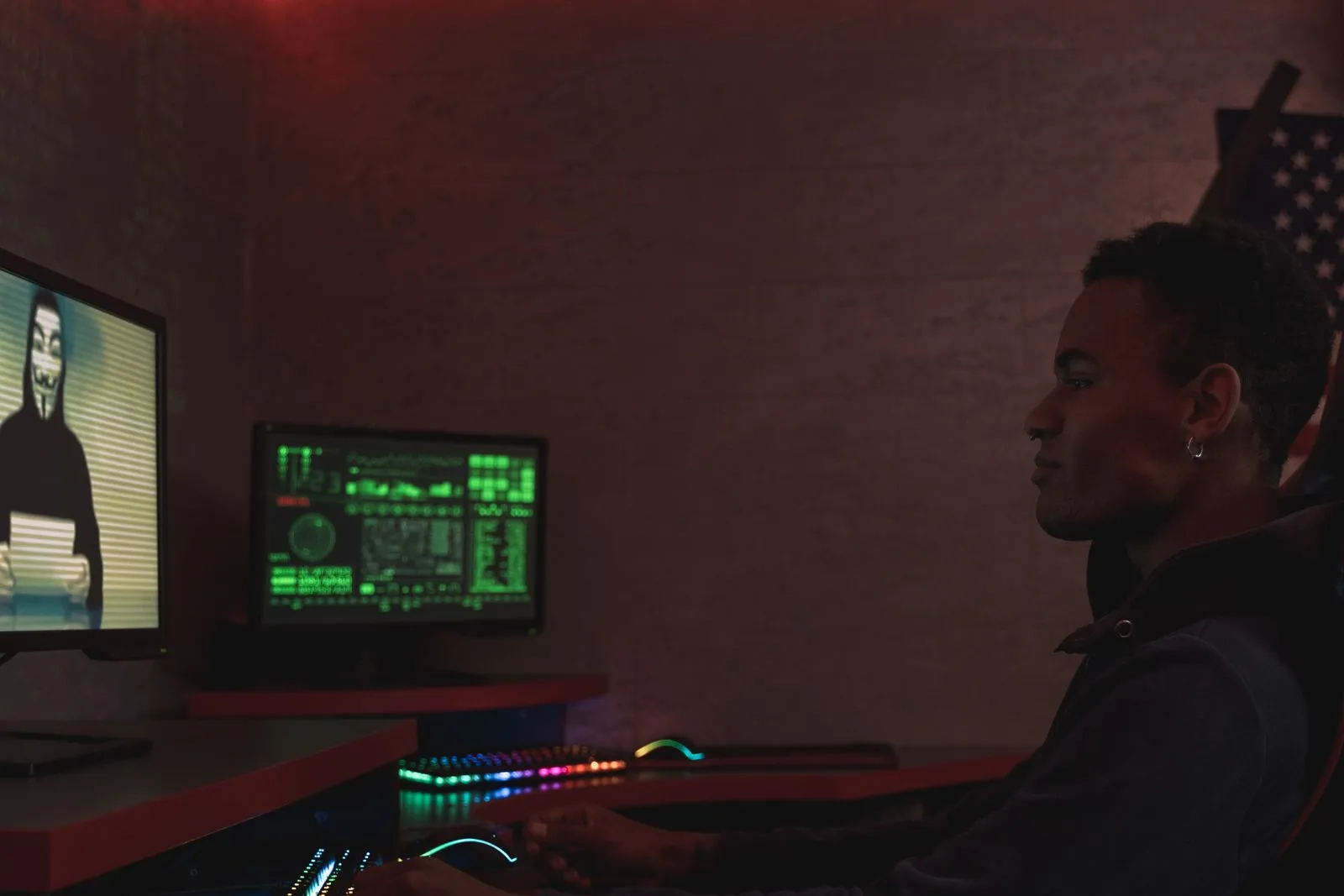 Person at a desk watching a monitor beside a masked video call while studying for the CEH certification