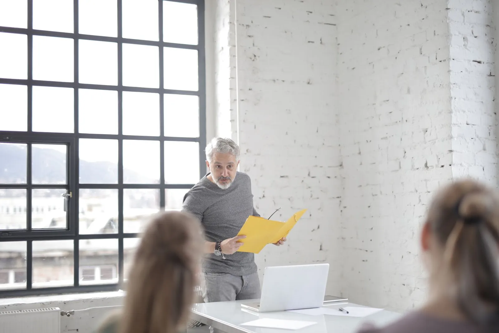 Gray-haired speaker answering a question in a boardroom about CISSP requirements and security experience